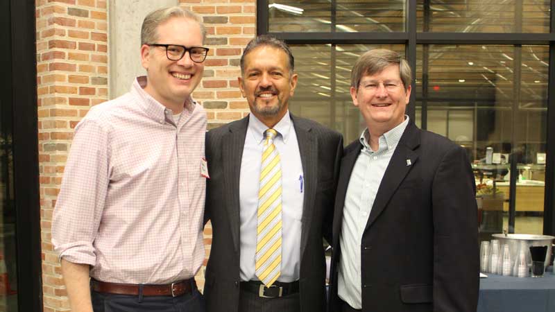 Three men standing looking at camera.