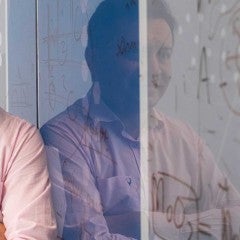 Aditya D. Mohite standing against wall in lab